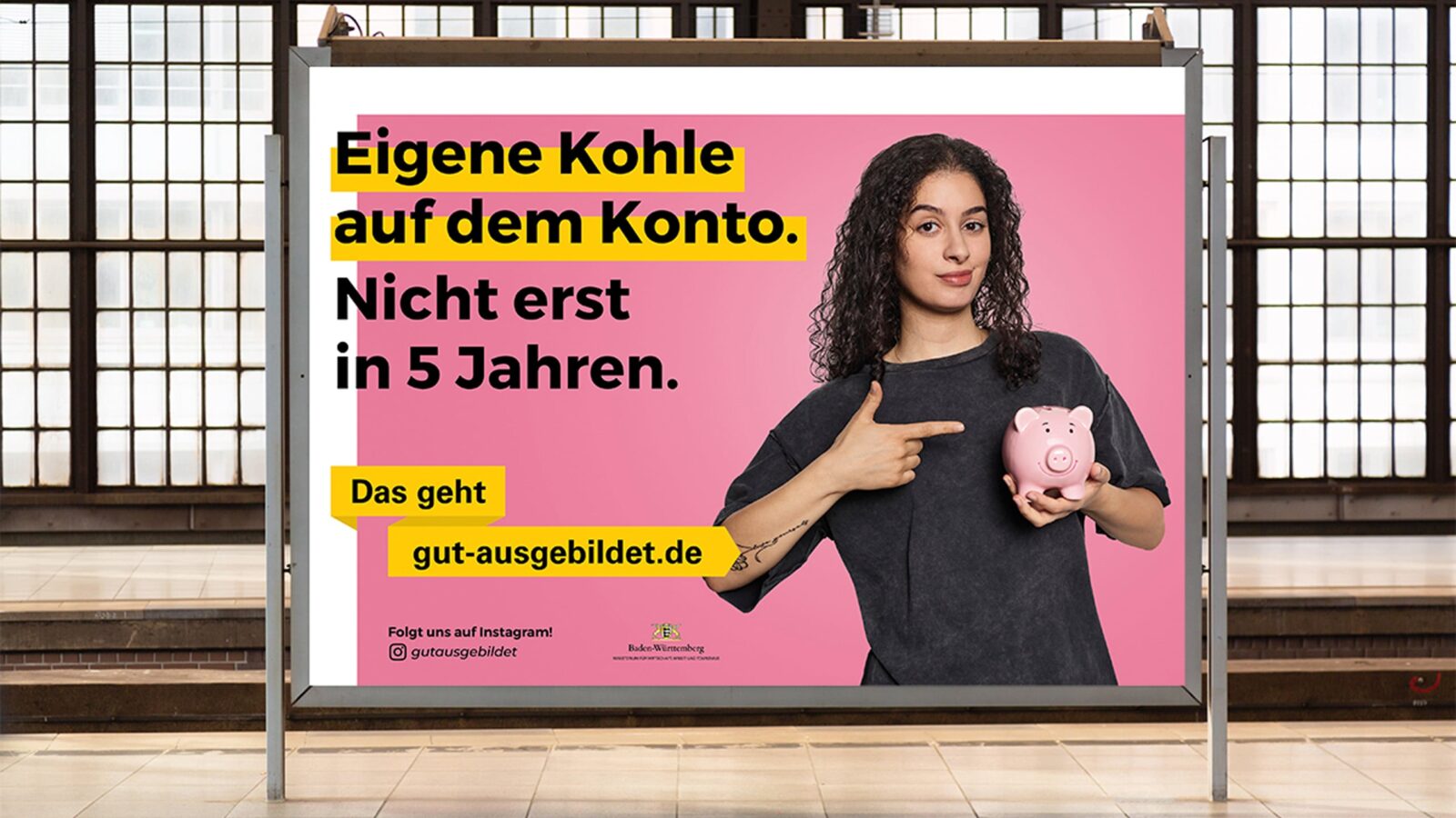 Plakat zeigt „gut ausgebildet” Werbung mit dem Schriftzug: „Eigene Kohle auf dem Konto. Nicht erst in 5 Jahren.” Daneben ist eine Frau die auf ein Sparschwein zeigt.